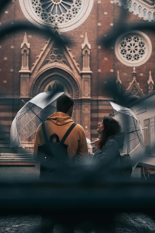 a man and a woman holding umbrellas in front of a church, pexels contest winner, visual art, romantic scene, melbourne, buenos aires, looking through a portal