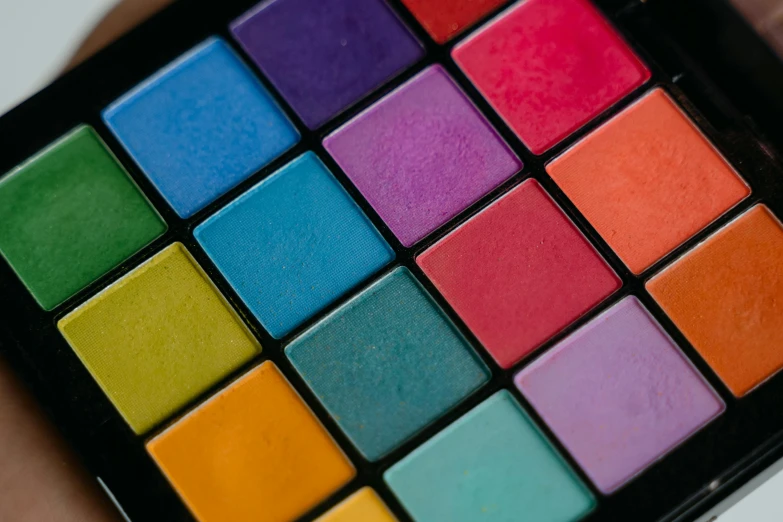 a close up of a person holding a colorful palette, trending on pexels, cosmetics, color block, 1 6 colors, colorful mosaic