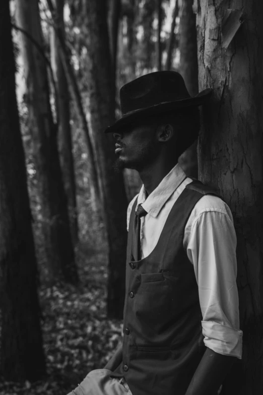 a black and white photo of a man leaning against a tree, unsplash, harlem renaissance, noir detective and a fedora, 2 1 savage, portrait of a slender elven man, profile picture