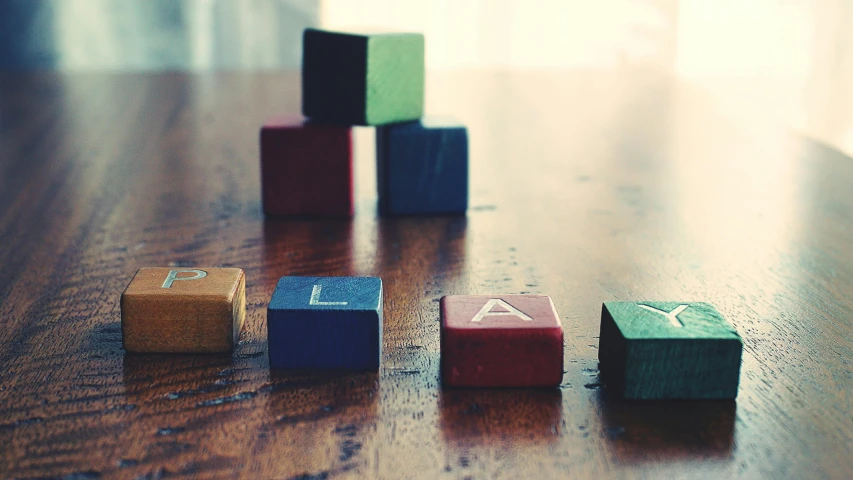 a group of wooden blocks sitting on top of a wooden table, by Emma Andijewska, unsplash, square, plan, chemistry, coloured