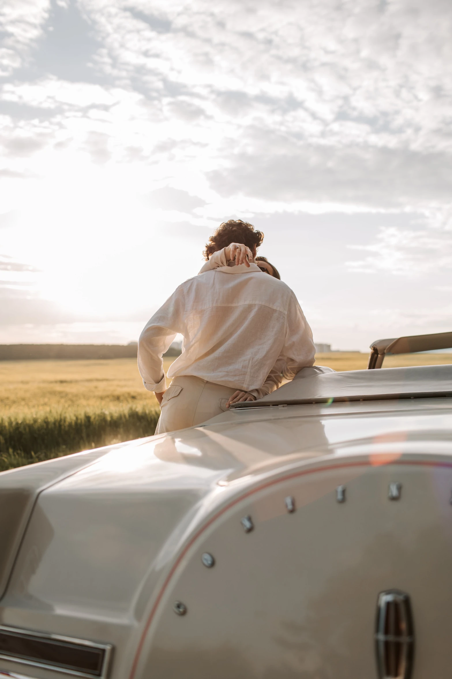 a woman sitting on the hood of a car, by Daniel Seghers, trending on unsplash, renaissance, in a wheat field, wearing a white button up shirt, private moment, conde nast traveler photo