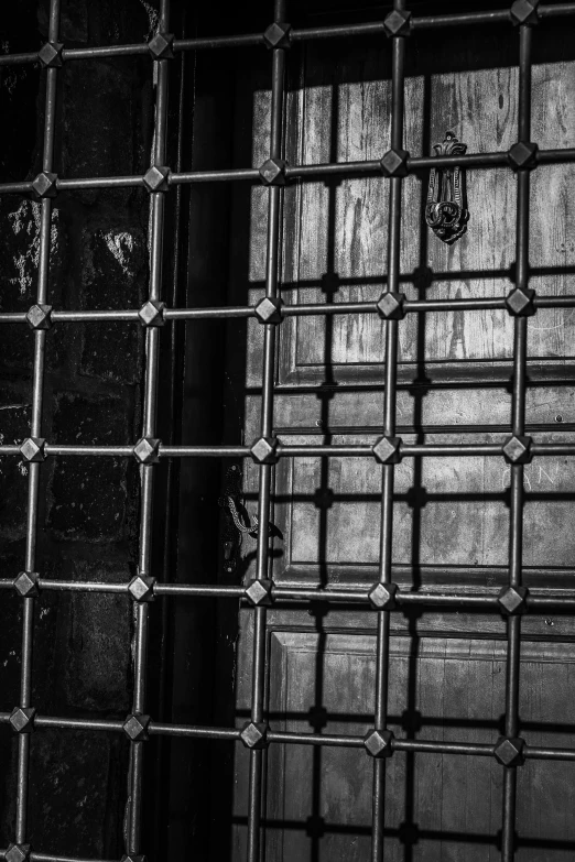 a black and white photo of a jail cell, a black and white photo, inspired by Brassaï, unsplash, renaissance, made of intricate metal and wood, square lines, stained glass, closeup!!!!!!