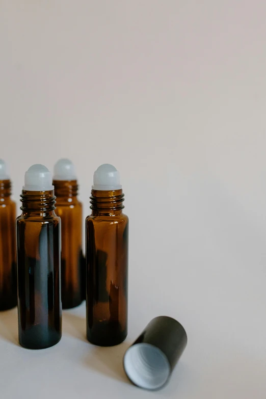 a group of bottles sitting on top of a table, product image, healing tubes, plain background, natural lights