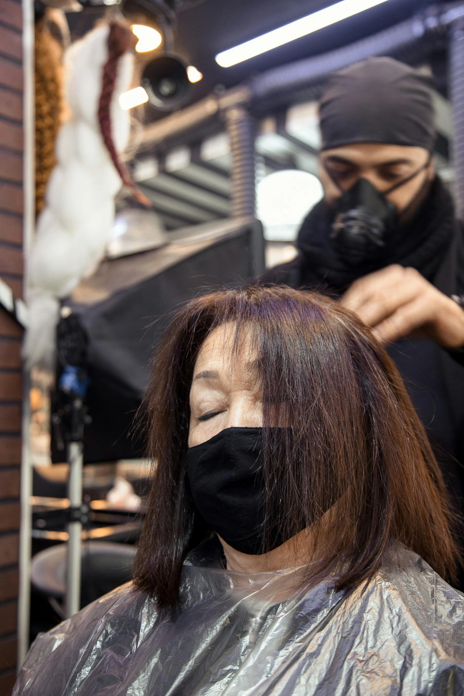 a woman getting her hair cut in a salon, wearing noh theatre mask, deep black roots, takato yomamoto, balaclava