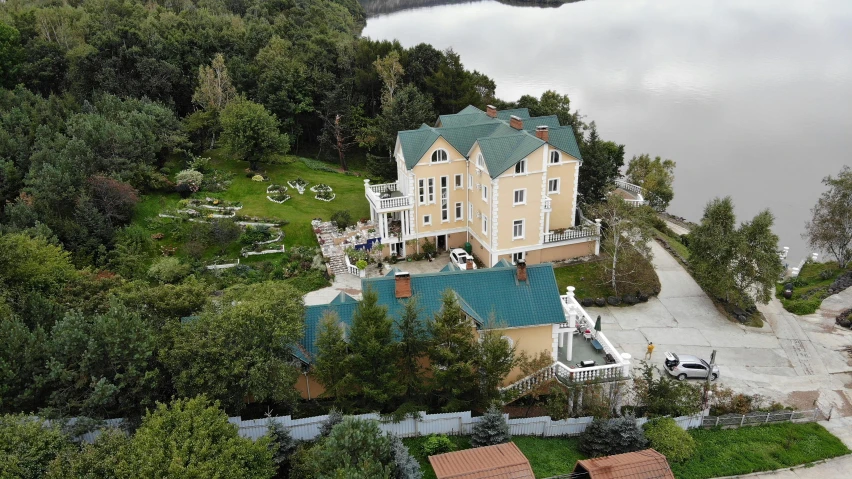 a large house sitting on top of a lush green hillside, inspired by Vladimir Borovikovsky, instagram, lake view, fpv, private school, exterior photo