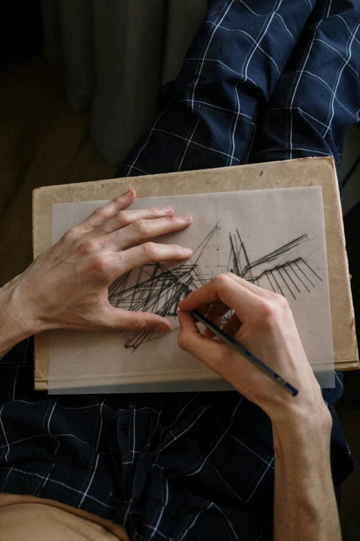 a man is drawing on a piece of paper, a drawing, inspired by Anna Füssli, pexels contest winner, visual art, holding a wood piece, realistic hands, lines and movement, movie photo
