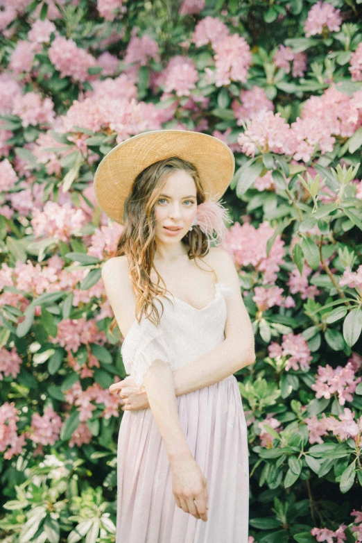 a woman standing in front of a bush of flowers, unsplash, renaissance, with straw hat, prima ballerina in rose garden, portrait sophie mudd, anna nikonova aka newmilky