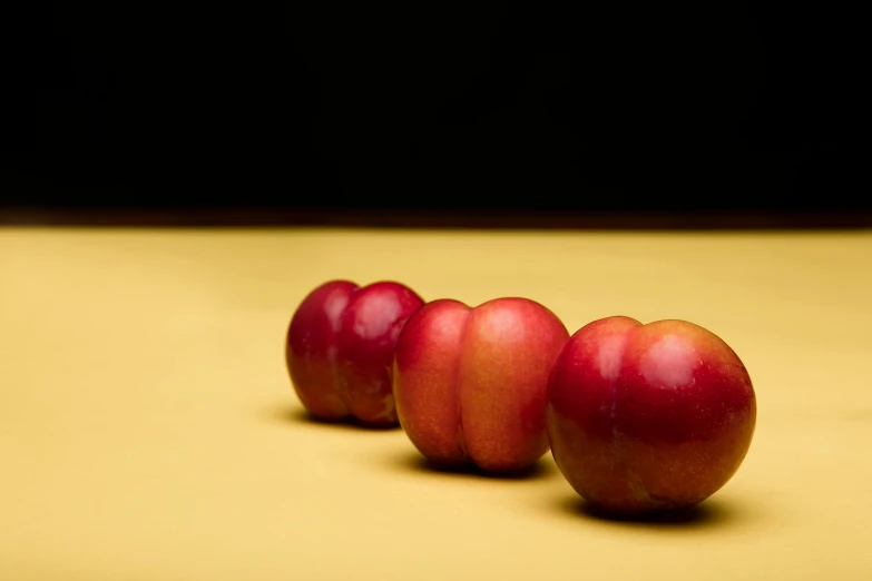 a row of red apples sitting on top of a table, a still life, inspired by Robert Mapplethorpe, unsplash, pink and yellow, 15081959 21121991 01012000 4k, photographed for reuters, smooth contours