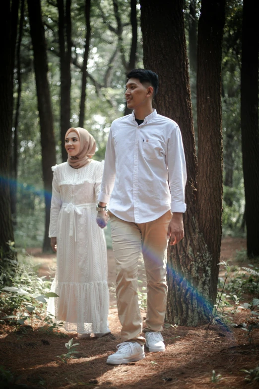 a man and a woman walking through a forest, a picture, by Basuki Abdullah, unsplash, hurufiyya, with a long white, a handsome, rustic, with vray