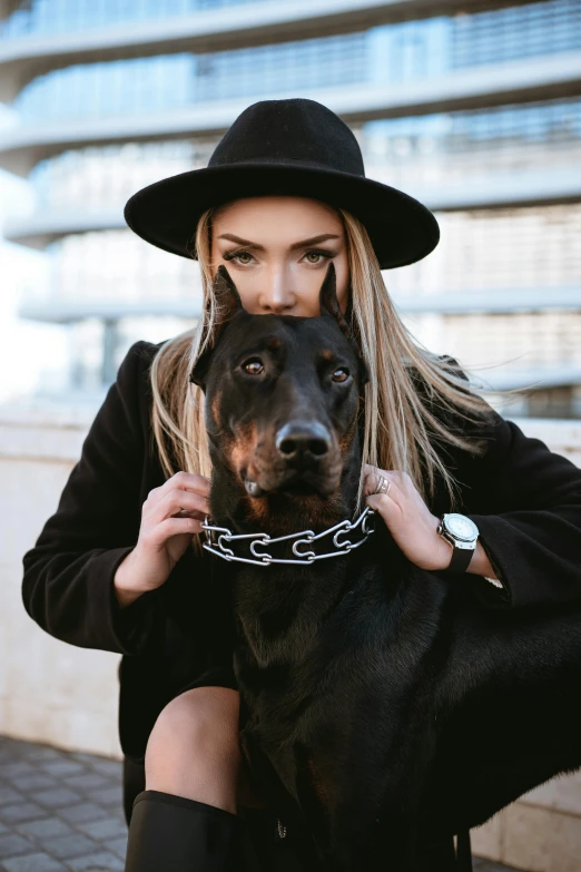 a woman in a black hat is holding a dog, trending on pexels, wearing steel collar, extremely handsome, 5 0 0 px models, square