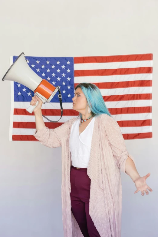 a woman holding a megaphone in front of an american flag, by Carey Morris, non-binary, promo image, subreddit / r / whale, studio shoot