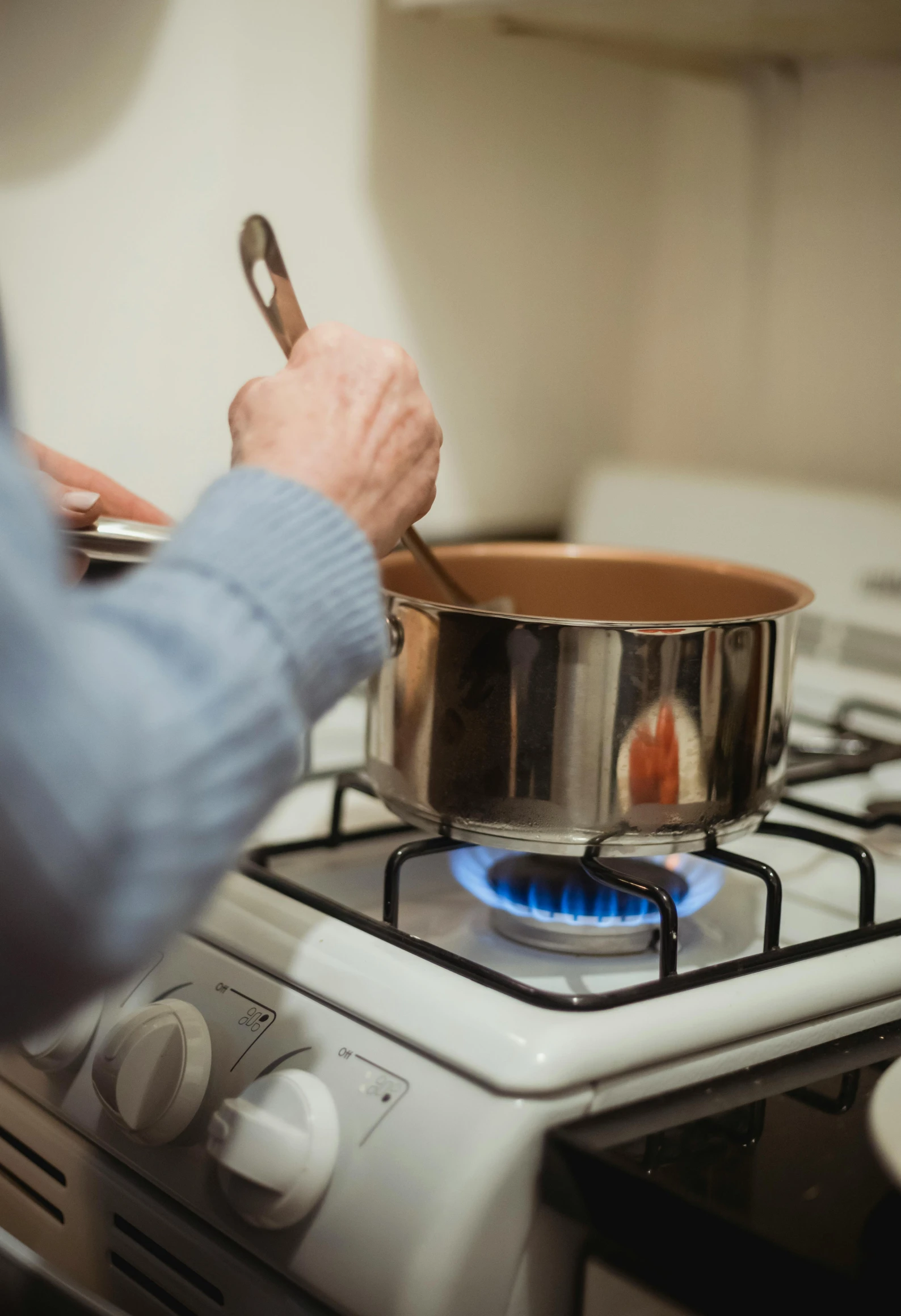 a person cooking food on a stove in a kitchen, brown, short spout, profile image, less detailing