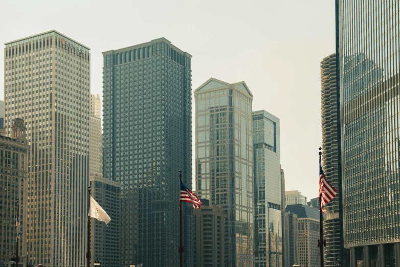 a city street filled with lots of tall buildings, inspired by Thomas Struth, pexels contest winner, hurufiyya, american flags, chicago skyline, digital banner, calatrava