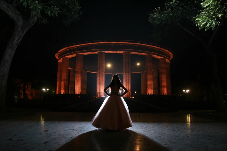 a woman standing in front of a building at night, by Gina Pellón, pexels contest winner, ornamental halo, rotunda, wedding, beautiful futuristic new delhi