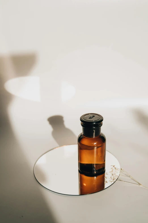 a brown glass bottle sitting on top of a white plate, unsplash, skincare, profile pic, medicine, oil