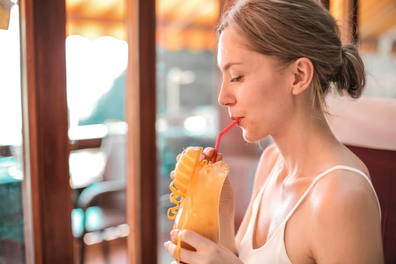 a woman drinking a drink out of a paper cup, pexels contest winner, tropical fruit, profile image, smooth tan skin, 🦩🪐🐞👩🏻🦳