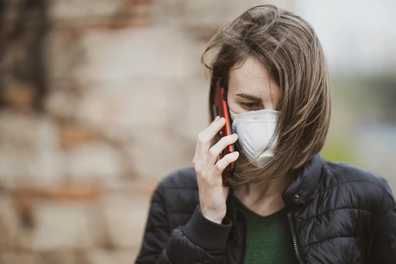 a woman wearing a face mask talking on a cell phone, a photo, by Emma Andijewska, trending on pexels, dust mask, pixar coronavirus movie, catastrophe, brown