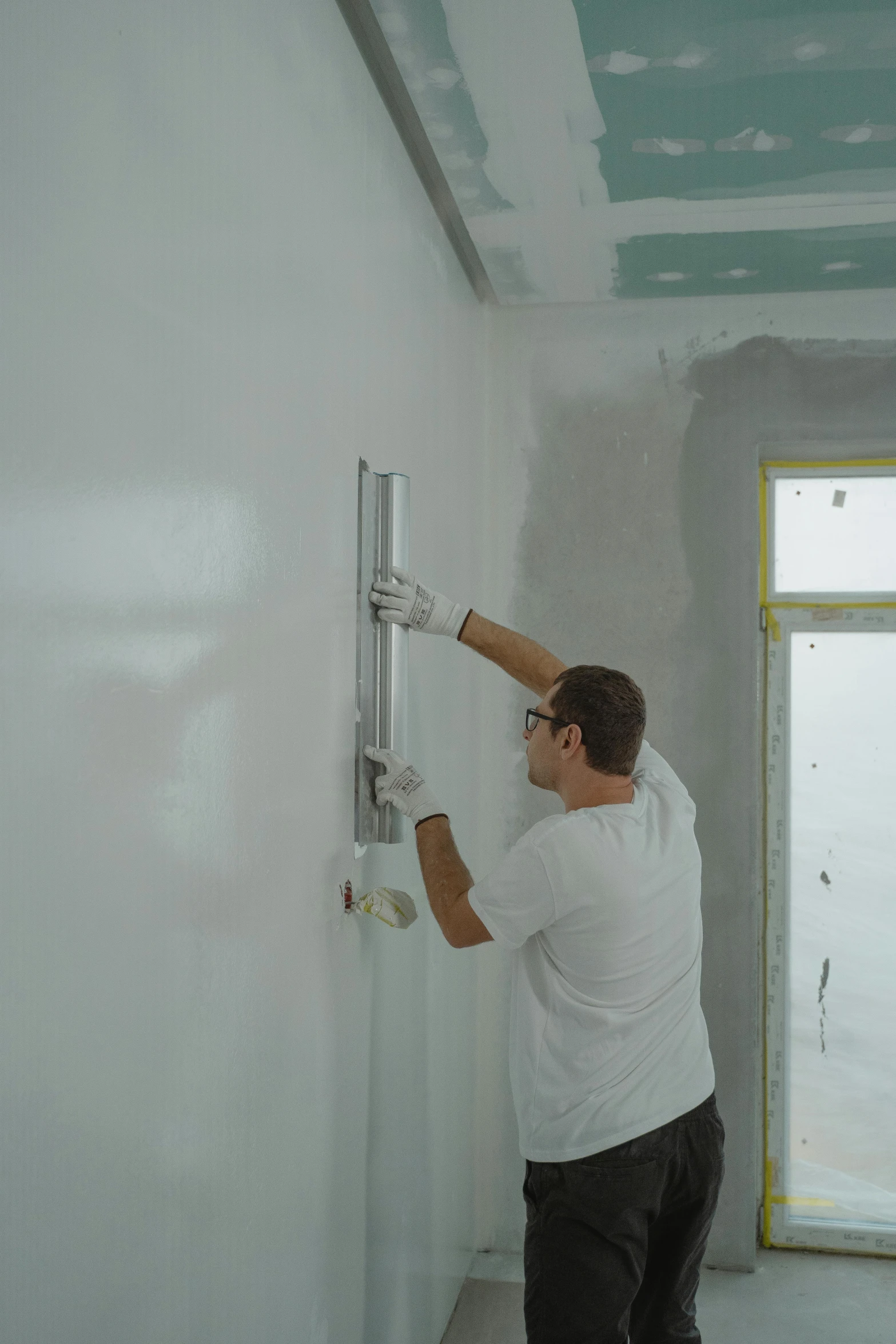 a man is painting a wall in a room, resin coated, фото девушка курит, wall ]