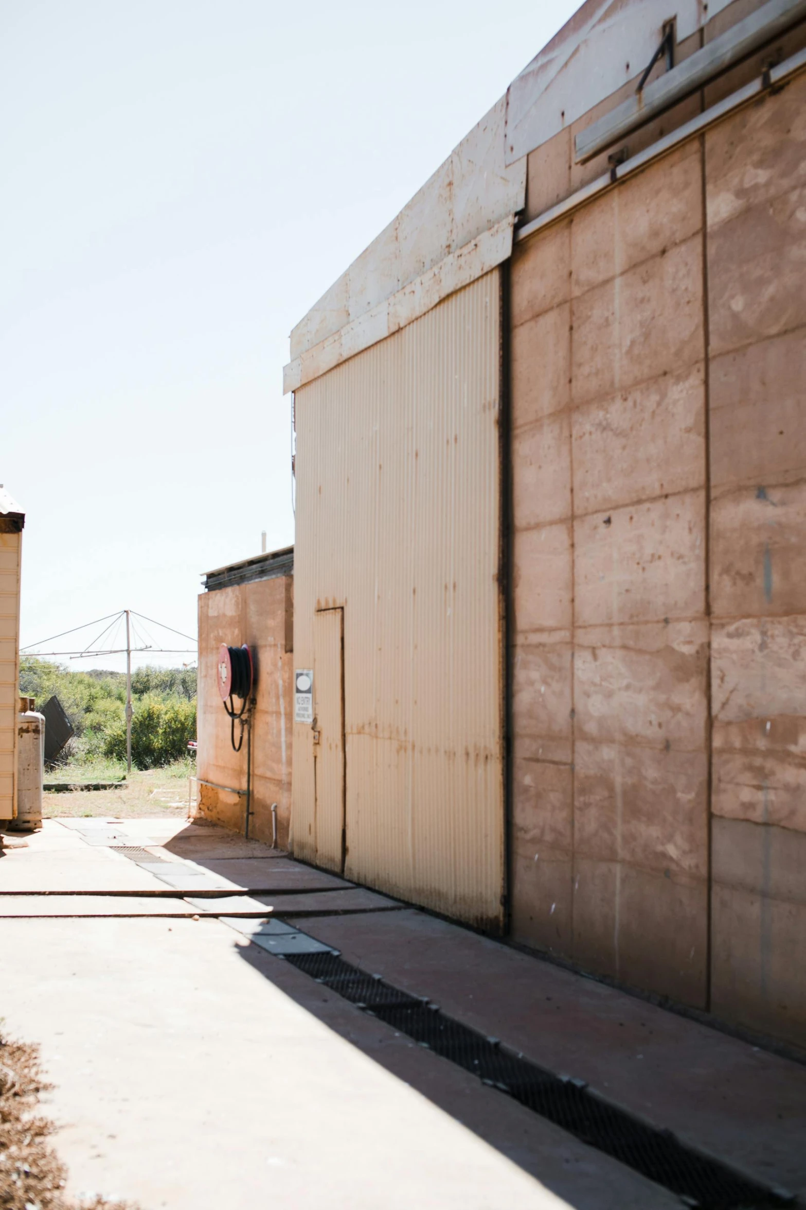 a man flying through the air while riding a skateboard, a portrait, by Lee Loughridge, unsplash, graffiti, entrance to 1900's mine, military base, a huge radar, rammed earth courtyard