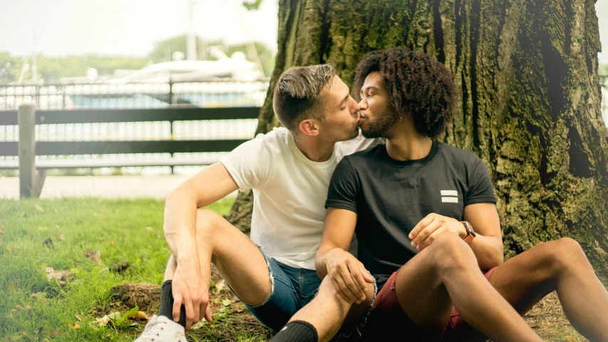 a man and a woman sitting under a tree, by Joe Bowler, pexels, renaissance, lesbian kiss, mixed race, two male, a pair of ribbed