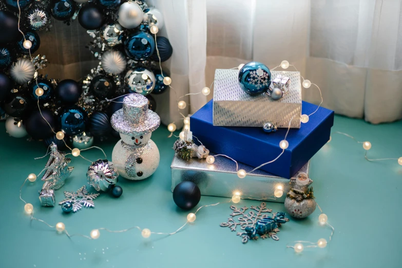 a pile of presents sitting on top of a table, blue and silver, string lights, thumbnail, jewelry lighting