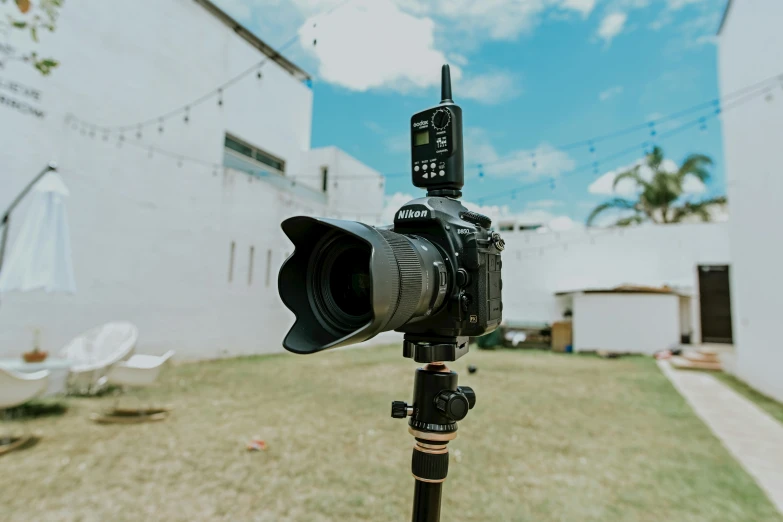 a camera sitting on top of a tripod in a yard, unsplash, youtube video screenshot, medium format, b - roll, shot from below