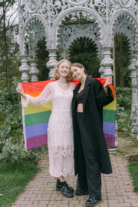 two women standing in front of a gazebo holding a rainbow flag, unsplash, renaissance, saoirse ronan, both smiling for the camera, olga buzova, alexandria ocasio-cortez