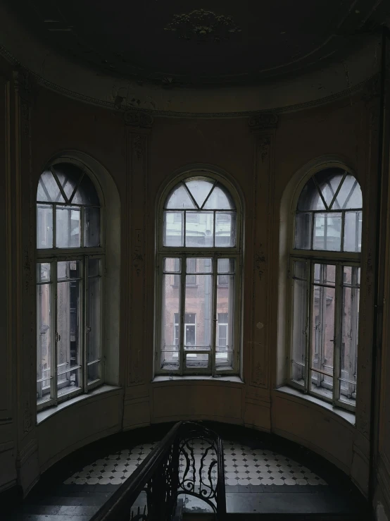 a room filled with lots of windows next to a staircase, inspired by Elsa Bleda, unsplash contest winner, neoclassicism, with great domes and arches, dark university aesthetic, photo of a beautiful window, taken in the early 1990s