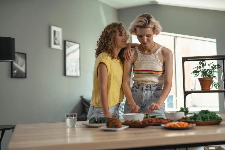 a couple of women standing next to each other in a kitchen, trending on pexels, lesbians, australian, ingredients on the table, serving suggestion