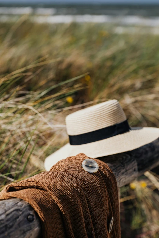 a hat sitting on top of a wooden fence, dunes in the background, award - winning crisp details, manuka, explorer