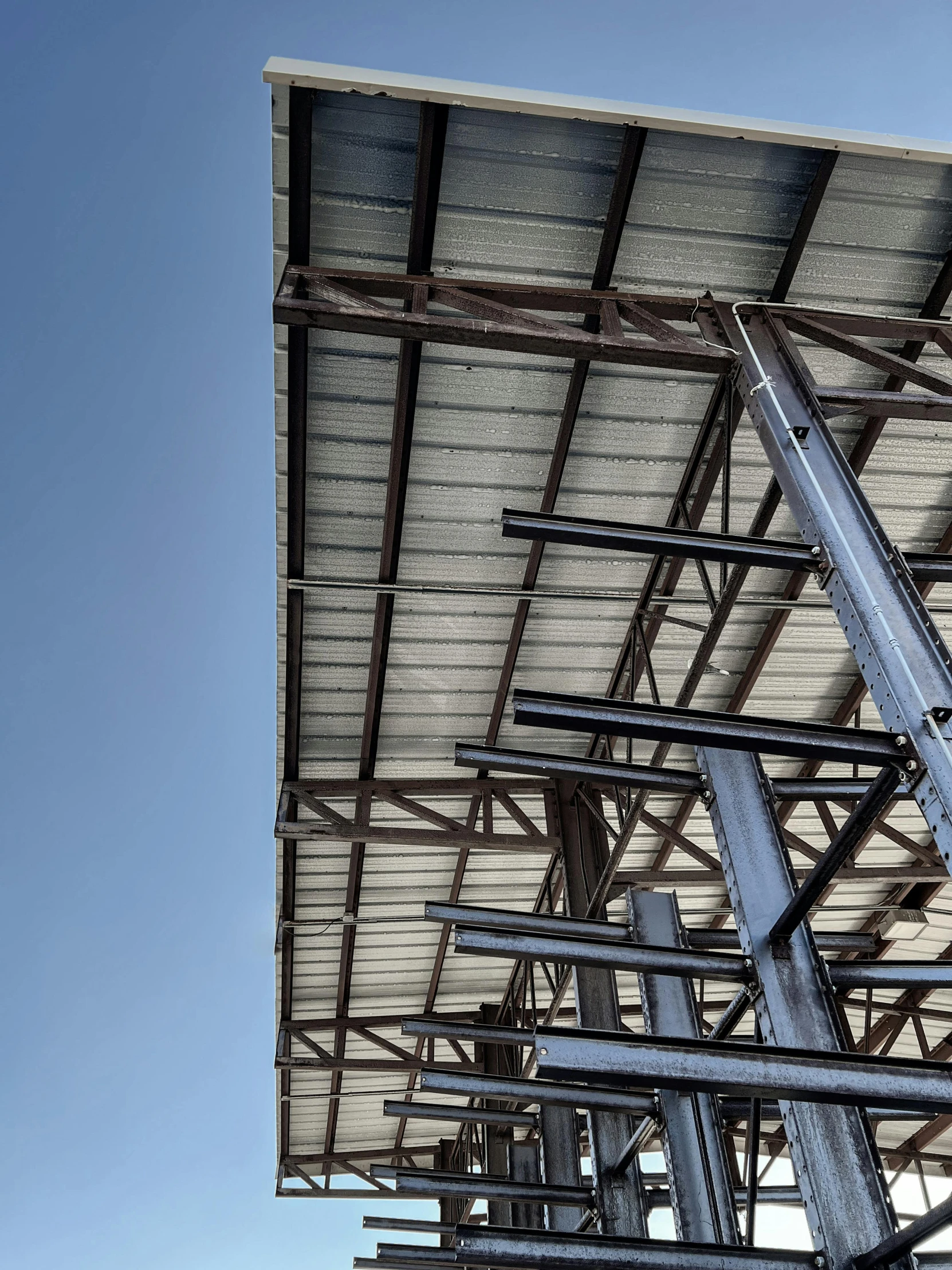 a large metal structure sitting under a blue sky, a portrait, unsplash, billboard image, close up shot from the side, modeled, construction