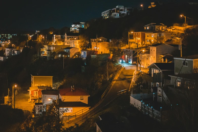 a view of a city at night from the top of a hill, by Alejandro Obregón, pexels contest winner, houses and roads, wellington, ground level view of soviet town, gif