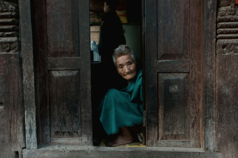 a woman sitting in a doorway of a building, a portrait, pexels contest winner, cloisonnism, he is about 8 0 years old, slide show, portrait image