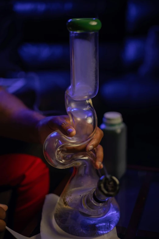 a close up of a person holding a water pipe, by Ryan Pancoast, night club, at home, essence, chemistry