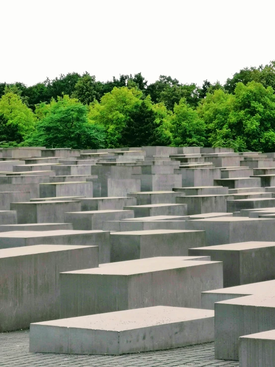 a field of concrete blocks with trees in the background, inspired by Adolf Born, pexels contest winner, berlin secession, with a long, rip, an ancient, to