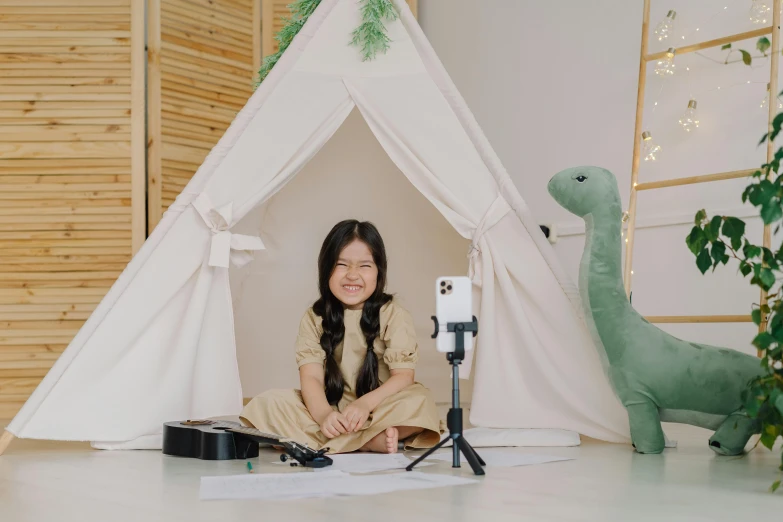 a woman sitting on the floor in front of a tent, inspired by Abidin Dino, pexels contest winner, video art, sitting in front of a microphone, female explorer mini cute girl, studio room, taejune kim