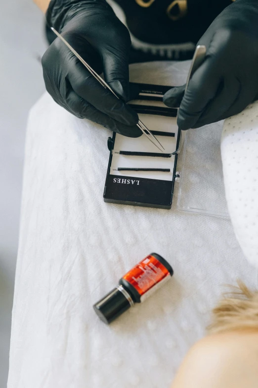 a woman getting her nails done at a salon, by Julia Pishtar, unsplash, visual art, blood collection vials, black and orange colour palette, label, detailed product shot