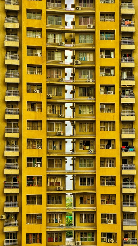 a tall yellow building with lots of windows, a photo, inspired by Zhang Kechun, flickr, 8k”, intricate ”, modern”