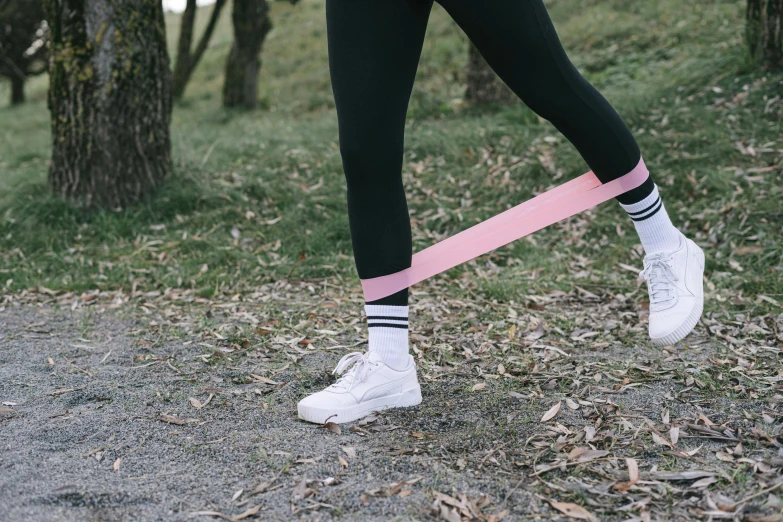 a woman in black leggings holding a pink ribbon, trending on pexels, outside on the ground, wearing white tights, pink and blue colour, plain stretching into distance