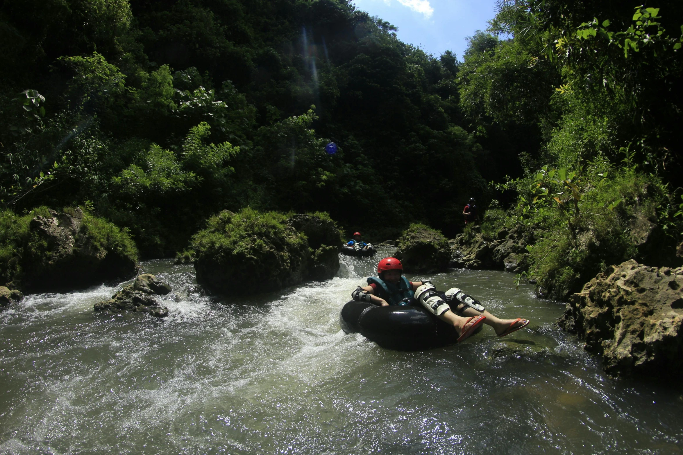 a man riding an inflatable tube down a river, by Daren Bader, pexels contest winner, sumatraism, samoan features, thumbnail, slide show, vine twist