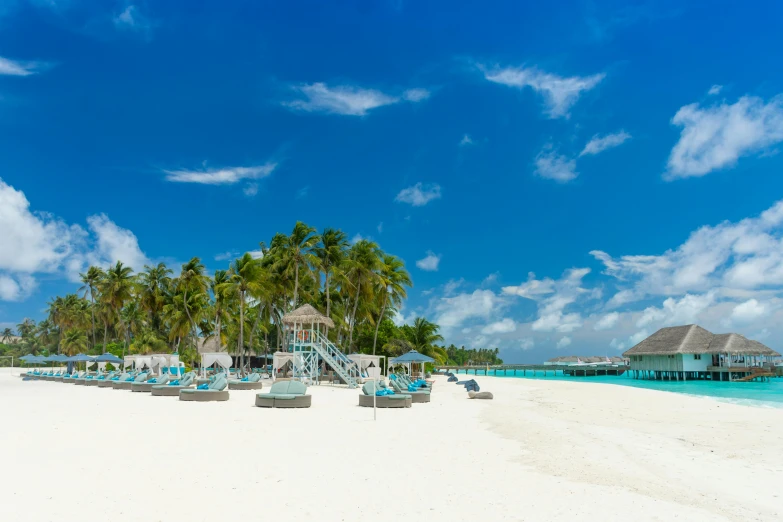 a group of lounge chairs sitting on top of a sandy beach, huts, turquoise, profile image, white sand