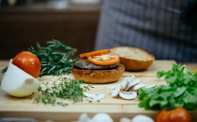 a burger sitting on top of a wooden cutting board, inspired by Richmond Barthé, pexels contest winner, private press, mushrooms grow from the body, hands on counter, profile image, thumbnail