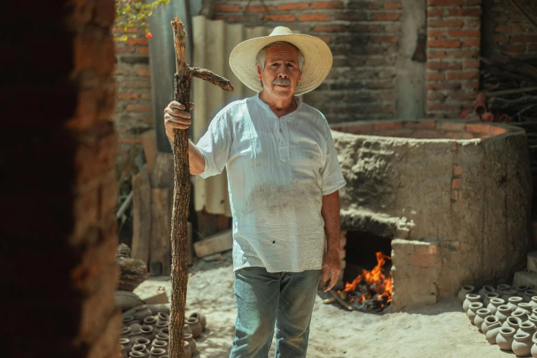 a man standing in front of a fire with a stick, a portrait, inspired by Agustín Fernández, pexels contest winner, farmer, standing in a cantina, avatar image, family photo