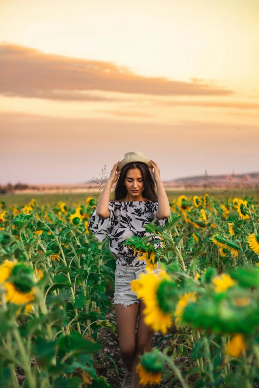 a woman standing in a field of sunflowers, a picture, by Julia Pishtar, pexels contest winner, model posing, tourist photo, sunset photo, handsome girl