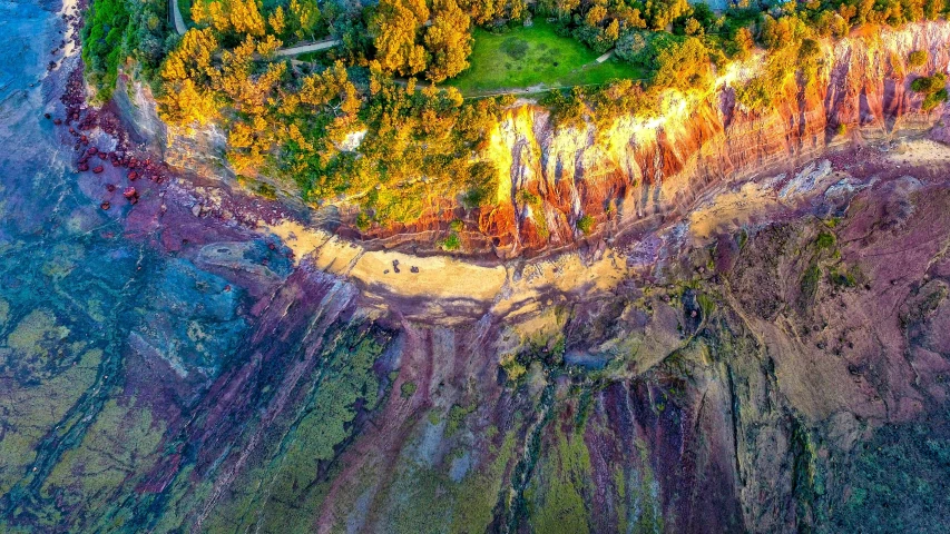 an aerial view of a small island surrounded by trees, by Julian Allen, pexels contest winner, land art, colorful ravine, shiny layered geological strata, te pae, extreme panoramic