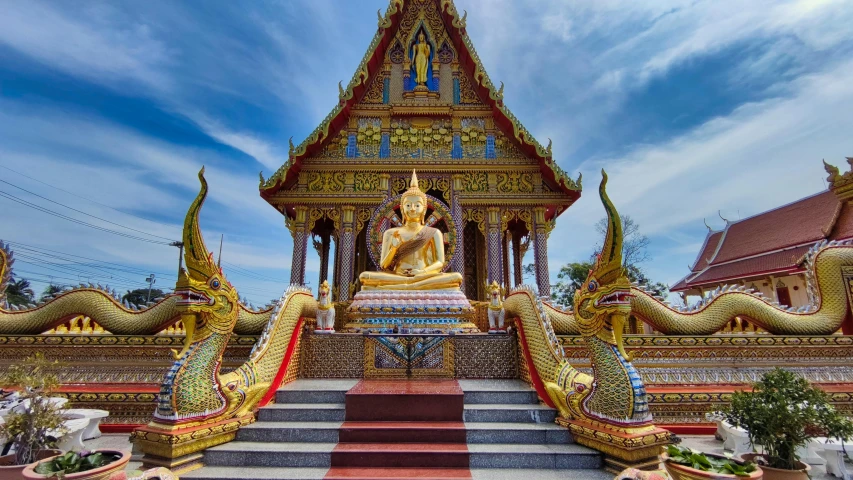 a statue that is sitting in front of a building, temples, gold and blue