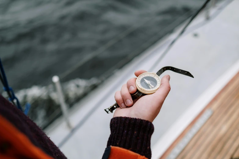 a person holding a compass on a boat, unsplash, happening, holding a cane, official product photo, dials, anato finnstark and kelogsloops