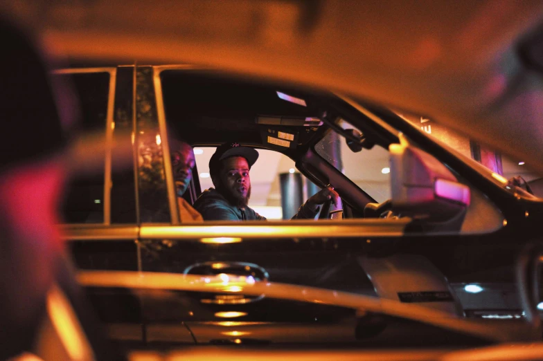 a man sitting in the driver's seat of a car, unsplash, happening, night clubs and neons, kendrick lamar, square, high resolution image