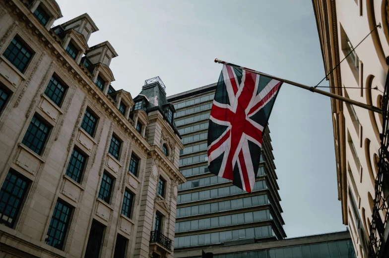 a british flag flying in front of a tall building, unsplash, fan favorite, portrait photo, profile image