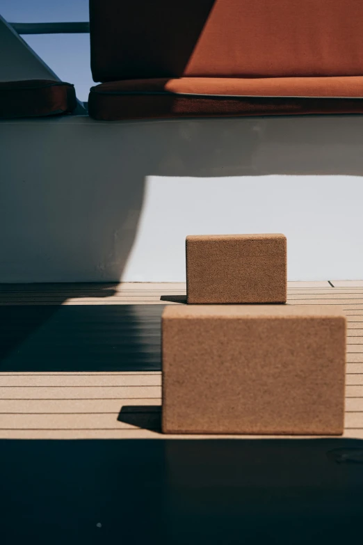 a brown box sitting on top of a wooden floor, an abstract sculpture, unsplash, ships, deck, sustainable, john pawson